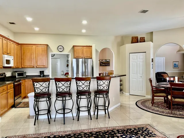 a kitchen with stainless steel appliances kitchen island granite countertop a table and chairs