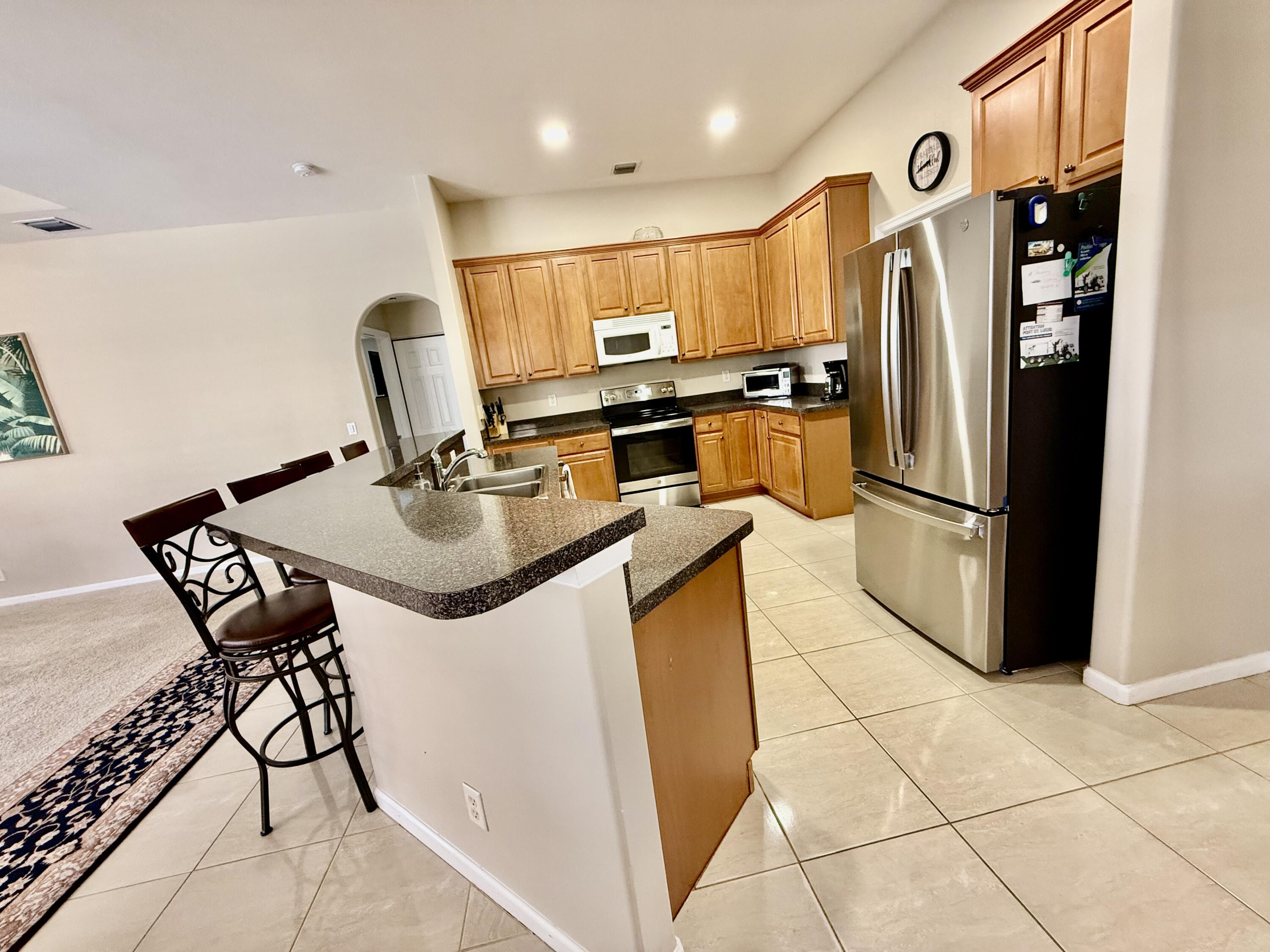 2810 Southeast Tate Avenue Port St. Lucie, FL 34984 - Photo 30 of 43 a kitchen with stainless steel appliances a refrigerator a stove a sink and a refrigerator