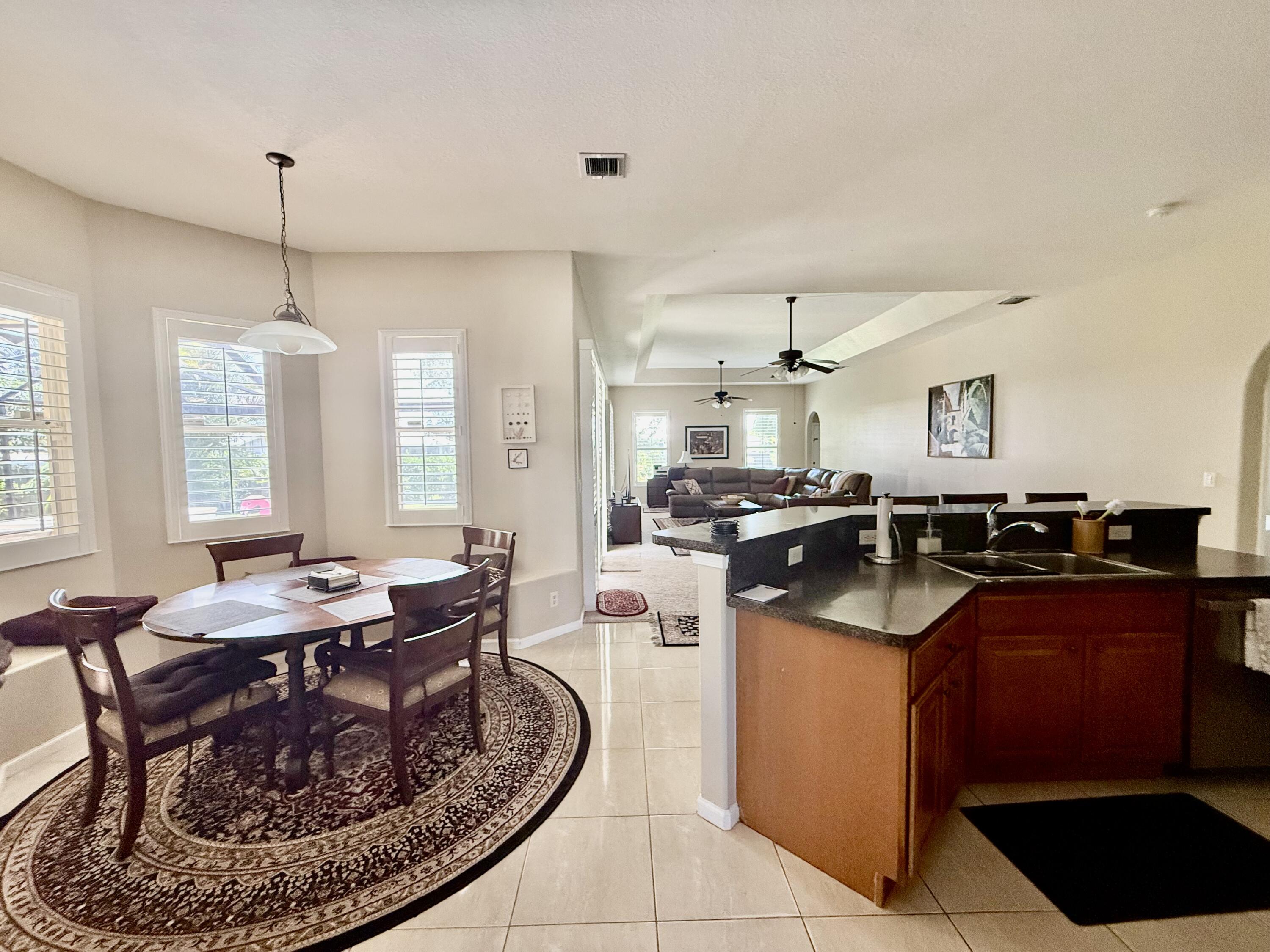 2810 Southeast Tate Avenue Port St. Lucie, FL 34984 - Photo 3 of 43 a kitchen with a sink stove and chairs