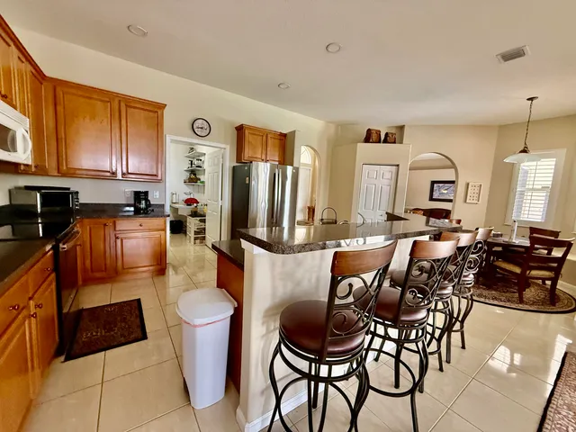 a living room with furniture a large window and kitchen view