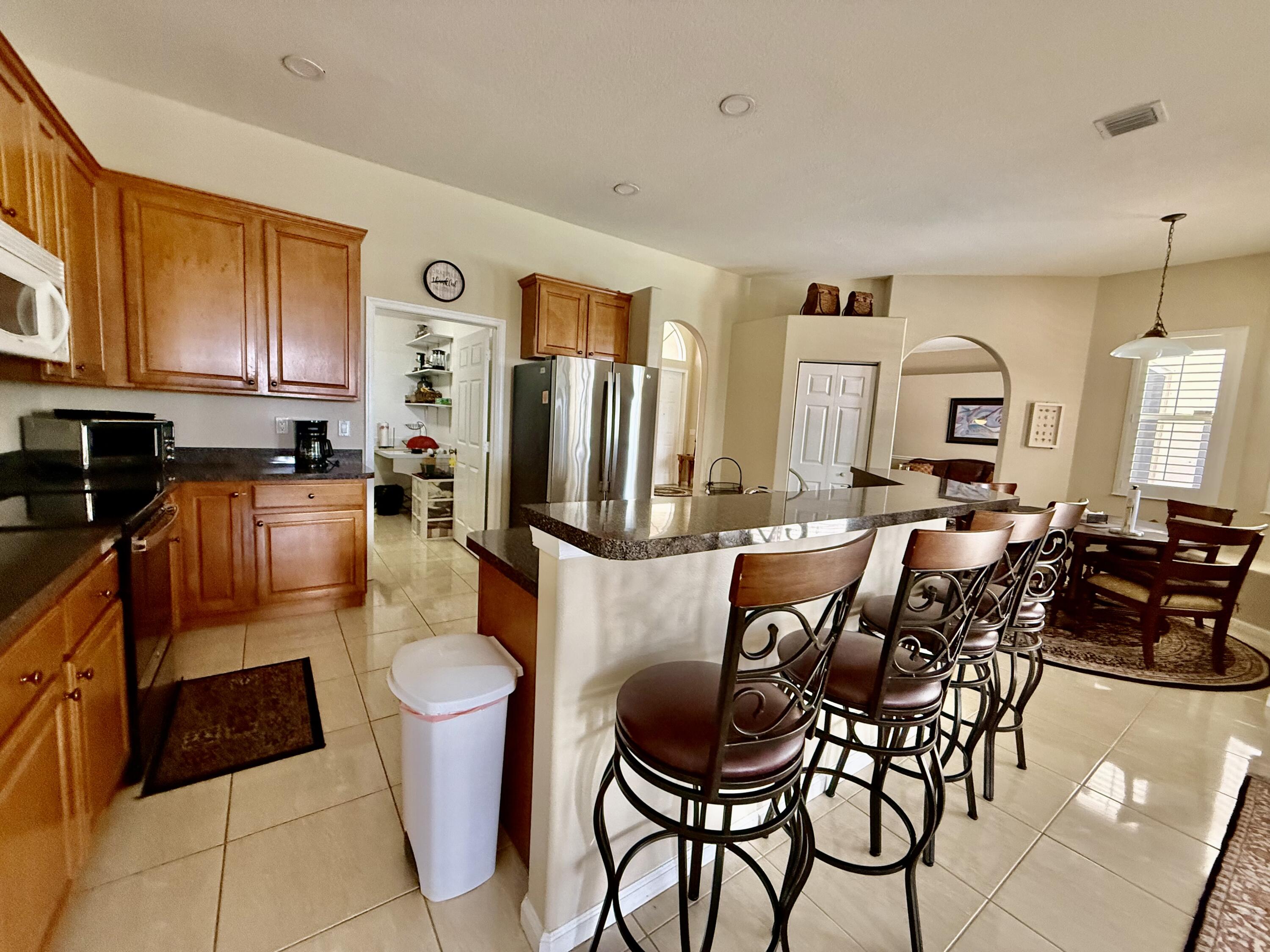 2810 Southeast Tate Avenue Port St. Lucie, FL 34984 - Photo 31 of 43 a living room with furniture a large window and kitchen view