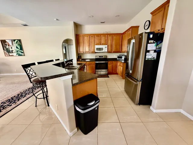 a kitchen with stainless steel appliances granite countertop a refrigerator stove and sink