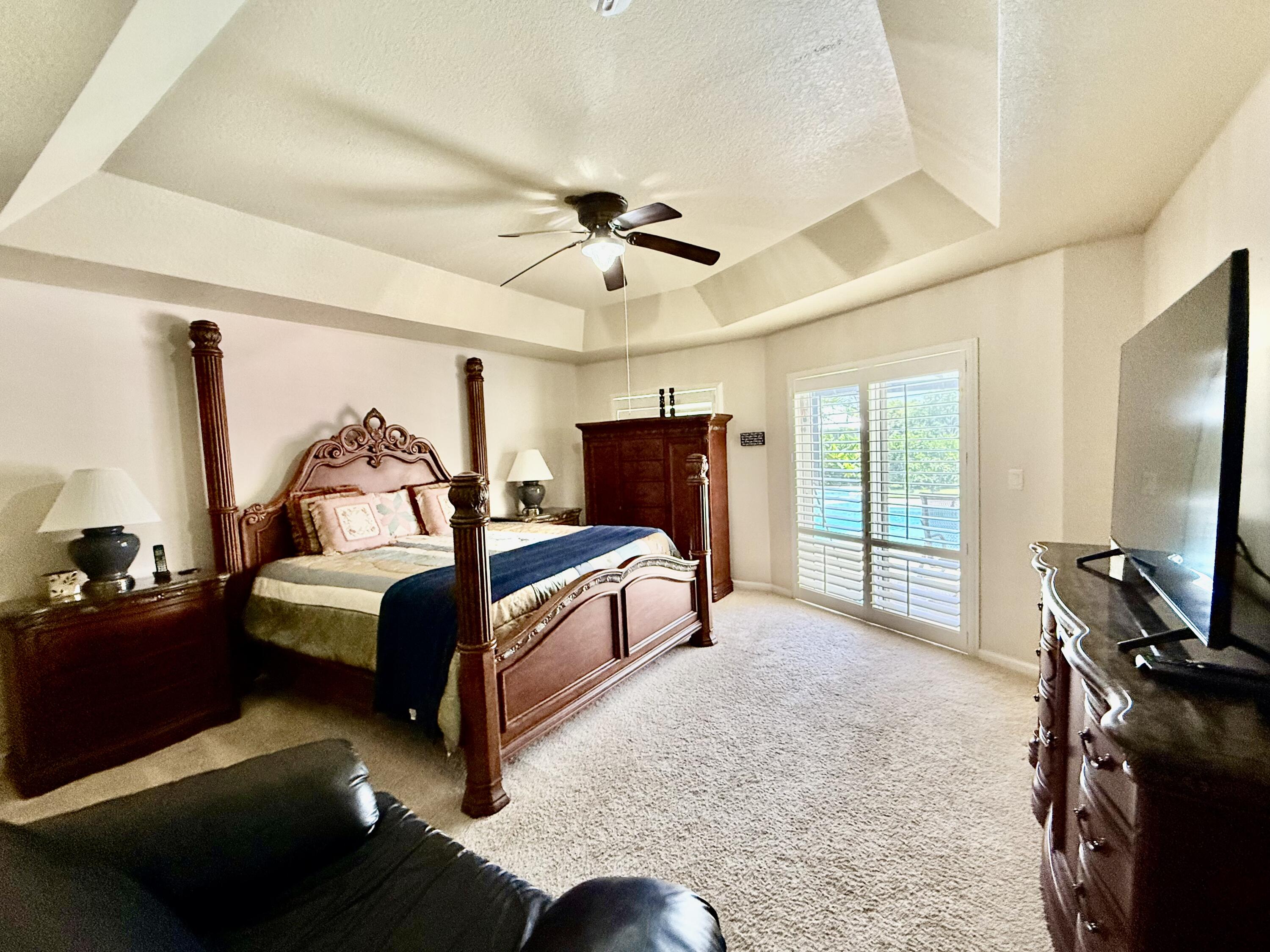 2810 Southeast Tate Avenue Port St. Lucie, FL 34984 - Photo 40 of 43 a bedroom with a bed and a flat tv screen on dresser