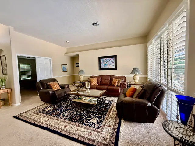 a living room with furniture a rug and a window