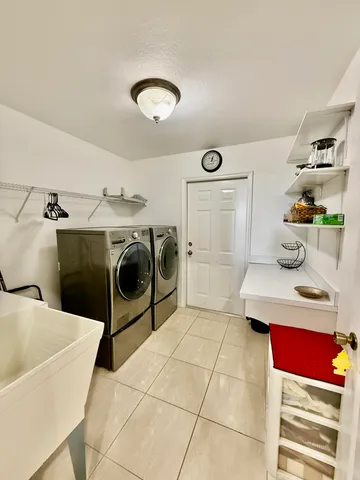a utility room with cabinets washer and dryer
