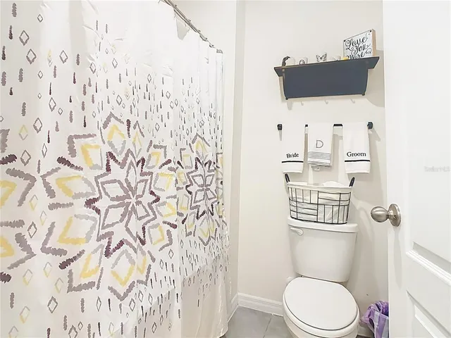 a white toilet sitting next to a shower curtain