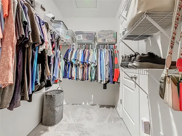 a view of walk in closet with clothes and shoes