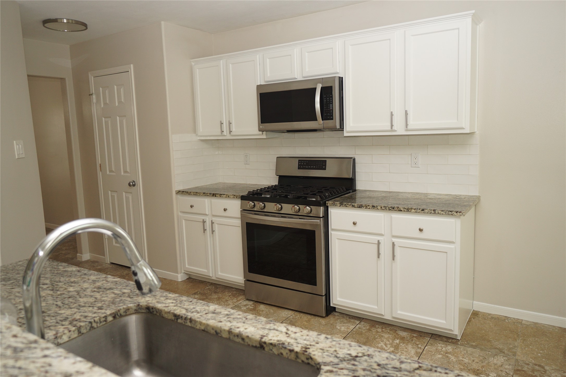 2434 Ranch Hollow Court Katy, TX 77494 - Photo 5 of 20 a kitchen with granite countertop white cabinets and stainless steel appliances
