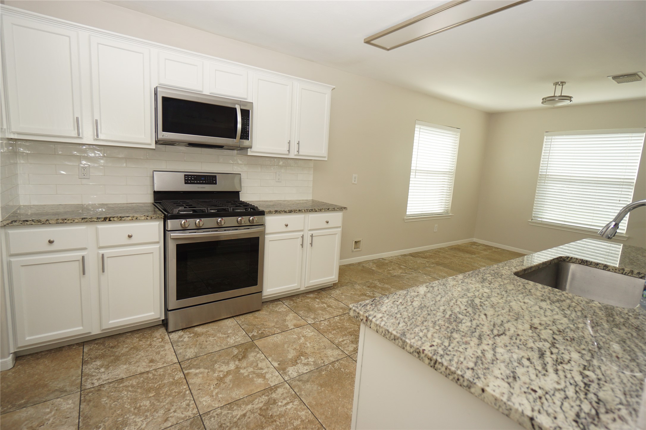 2434 Ranch Hollow Court Katy, TX 77494 - Photo 6 of 20 a kitchen with granite countertop a sink stove top oven and microwave