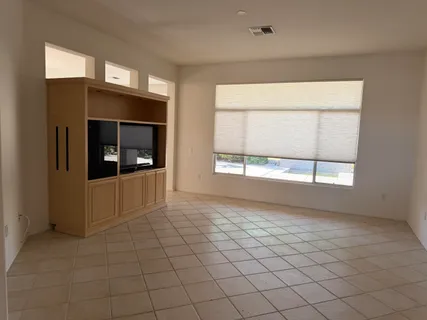 a view of an empty room with a fireplace and a window