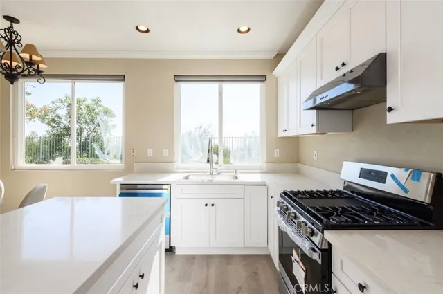 a kitchen with a stove a sink and a window
