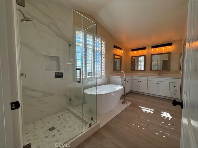 a spacious bathroom with a granite countertop sink a mirror and shower