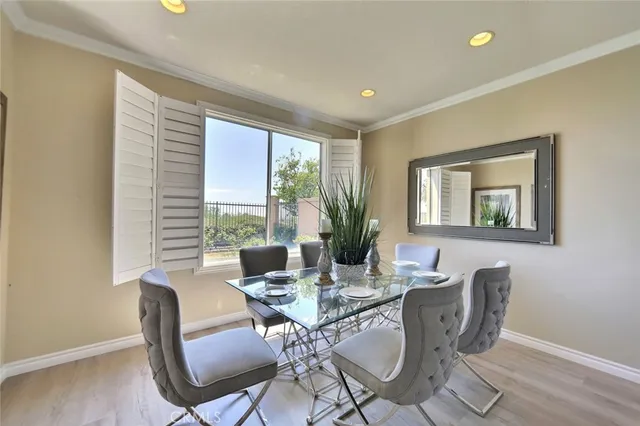 a dining room with furniture a large window and wooden floor