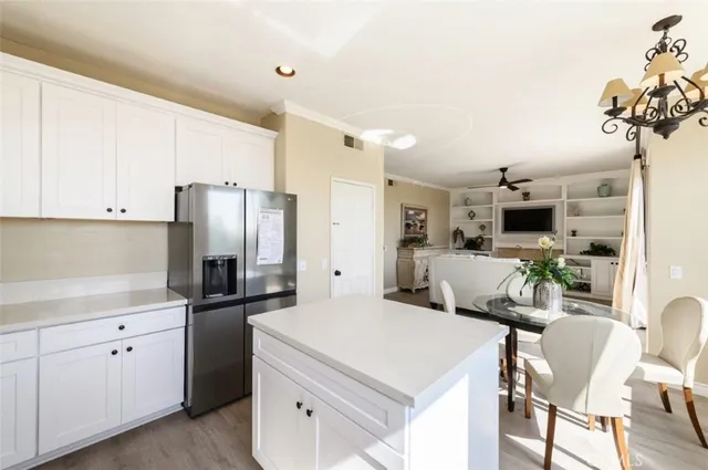 a kitchen that has a lot of white cabinets and stainless steel appliances