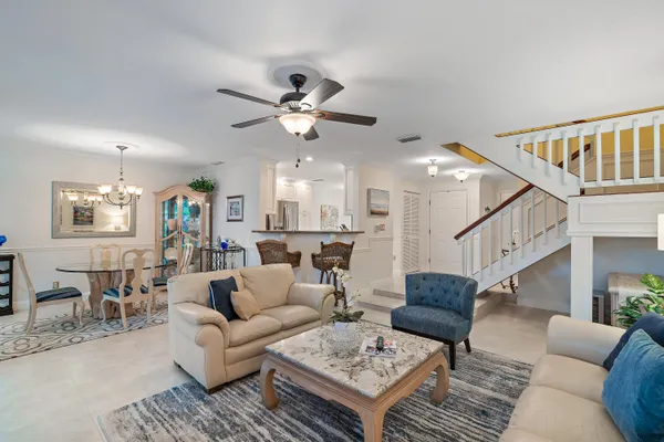 a living room with furniture a ceiling fan and a rug