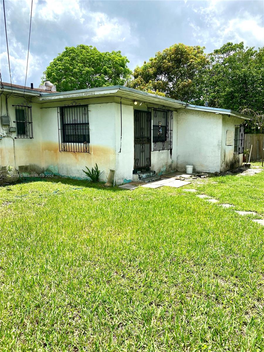 911 Northwest 138th Street Miami, FL 33168 - Photo 13 of 14 a front view of a house with a yard and garage