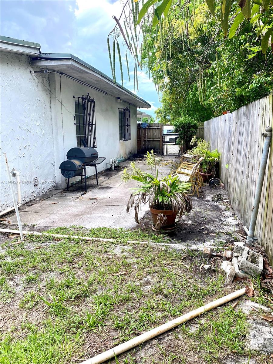 911 Northwest 138th Street Miami, FL 33168 - Photo 14 of 14 a view of a chair and table in backyard of the house