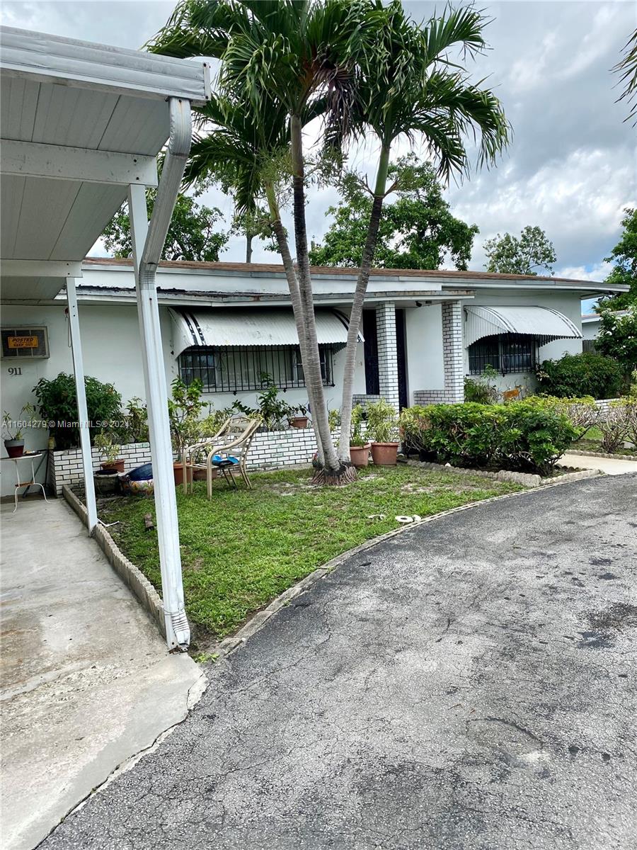 911 Northwest 138th Street Miami, FL 33168 - Photo 4 of 14 a view of a house with a yard and potted plants