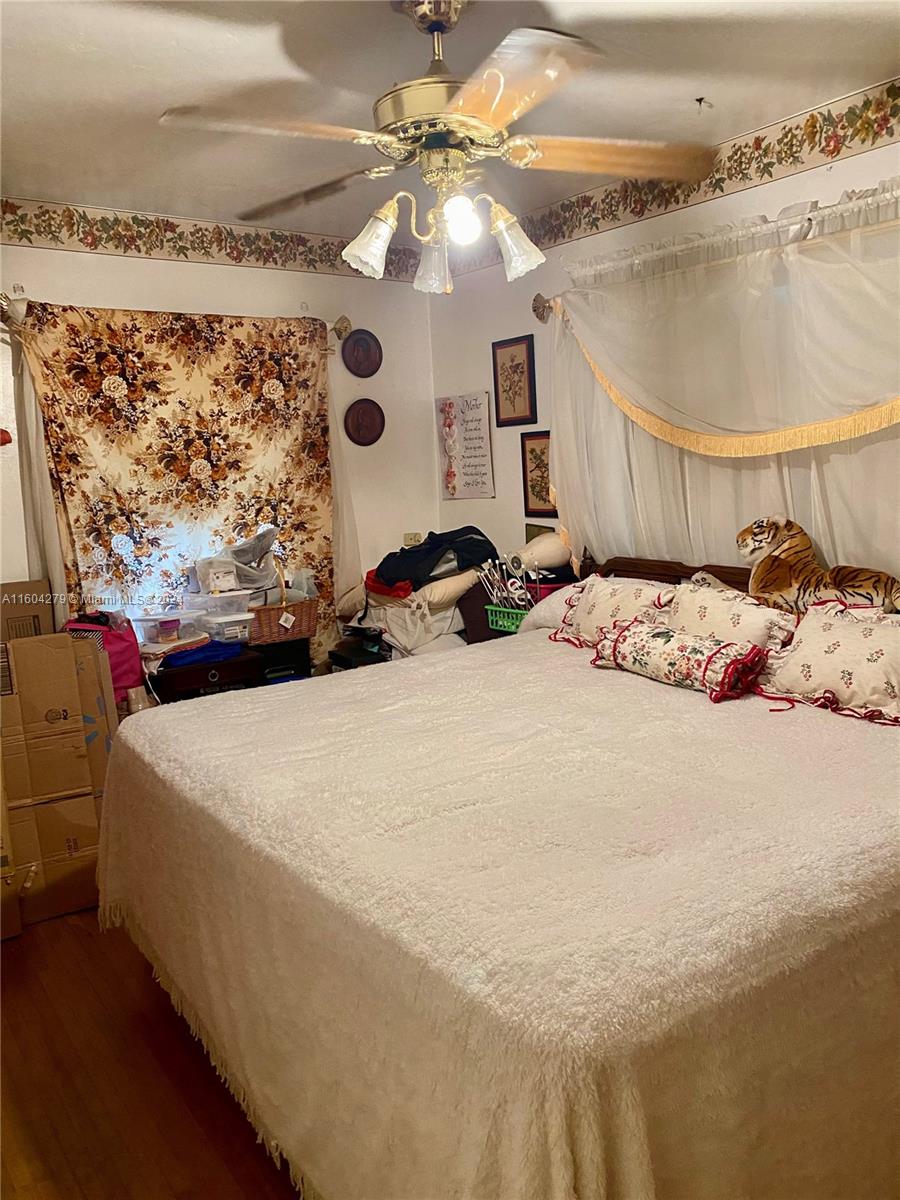 911 Northwest 138th Street Miami, FL 33168 - Photo 8 of 14 a bed sitting in a bedroom and chandelier