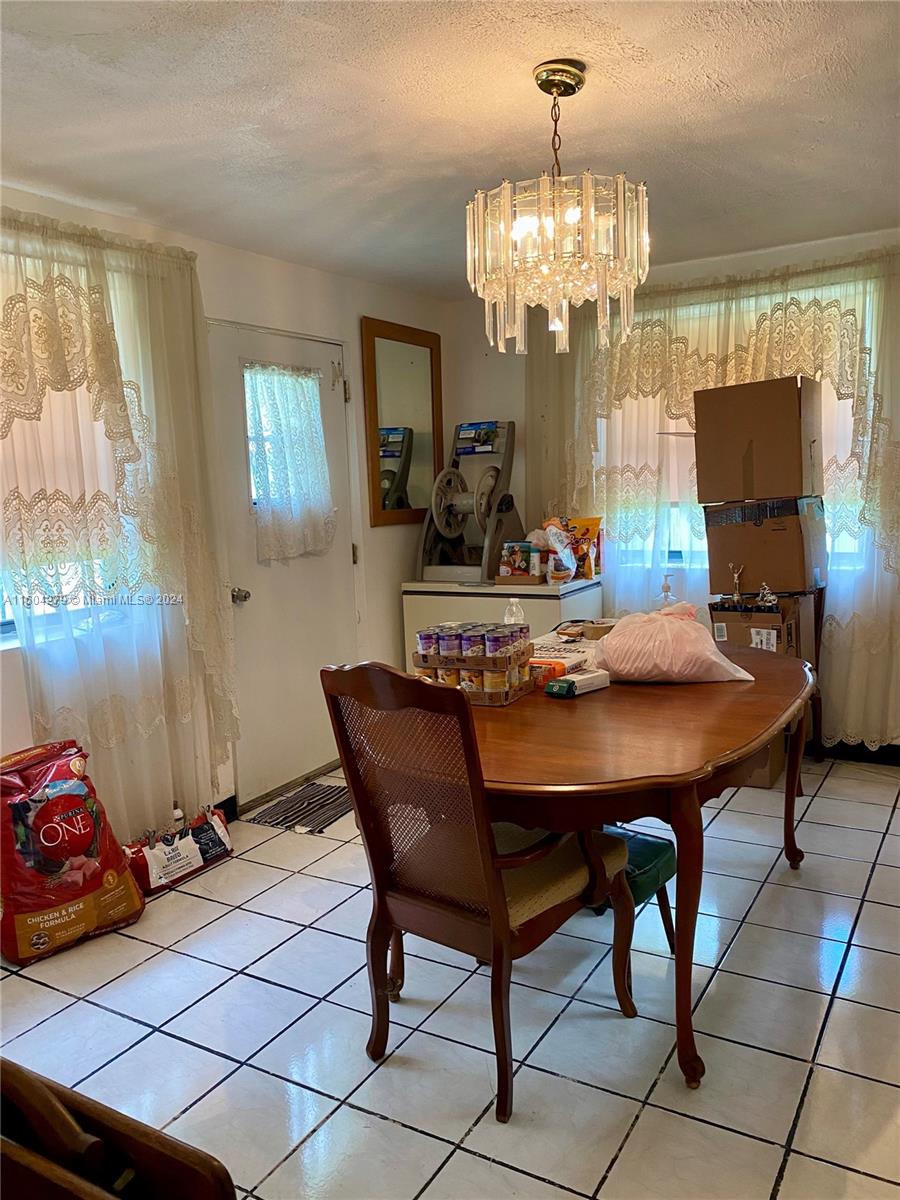 911 Northwest 138th Street Miami, FL 33168 - Photo 10 of 14 a view of a dining room with furniture and a chandelier