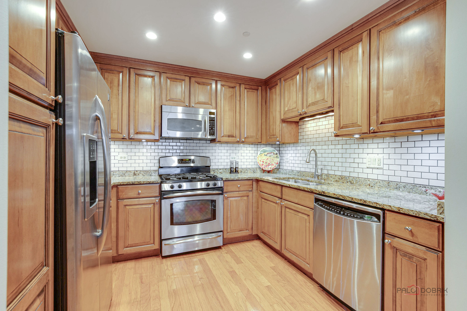 125 North Buffalo Grove Road, Unit 306 Buffalo Grove, IL 60089 - Photo 11 of 19 a kitchen with stainless steel appliances granite countertop a stove a sink and a refrigerator