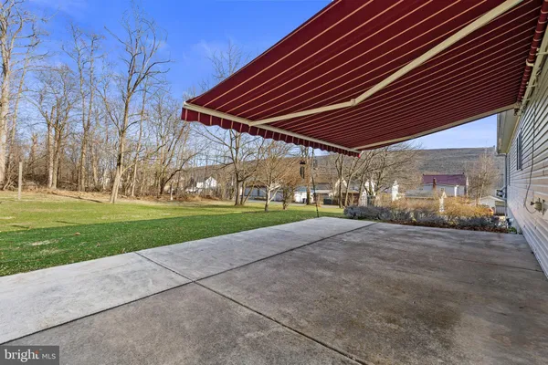 a view of a house with backyard and trees