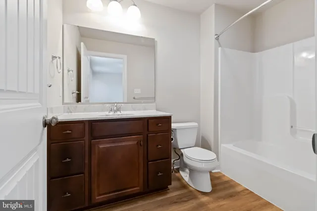 a bathroom with a granite countertop toilet sink and mirror