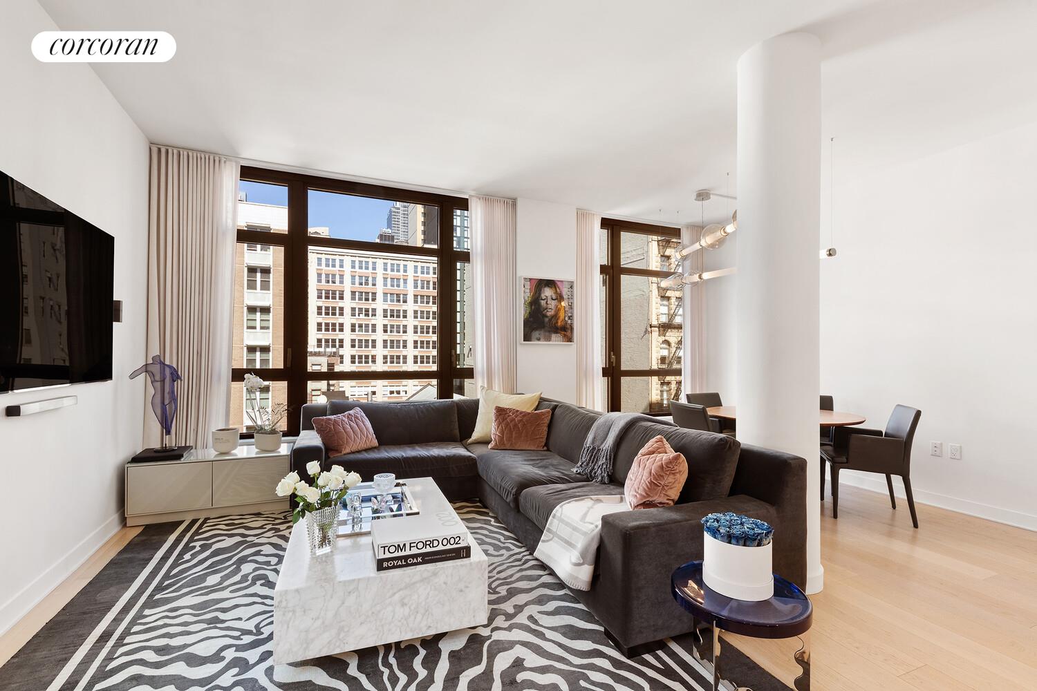 a living room with furniture a flat screen tv and a large window