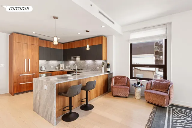 a living room with furniture a large window and kitchen view