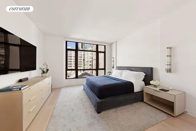 a spacious bedroom with a bed and a flat screen tv