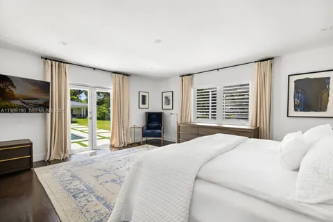 a bedroom with a bed a fireplace and a large window with the outer view
