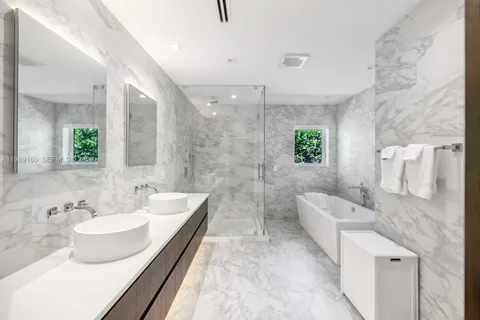 a spacious bathroom with a double vanity sink a mirror and a bathtub