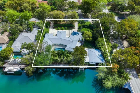 an aerial view of residential houses with outdoor space and lake view