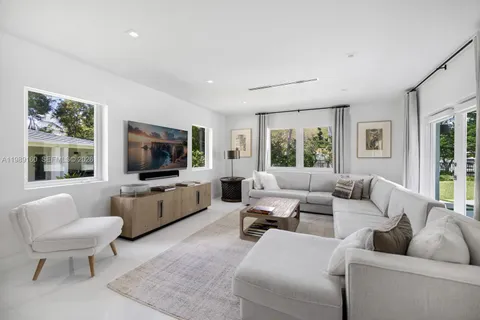 a living room with furniture flat screen tv and a large window