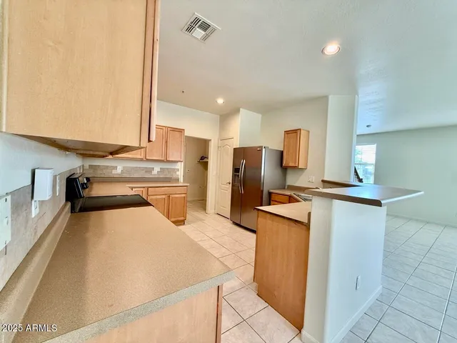 a kitchen with refrigerator and cabinets