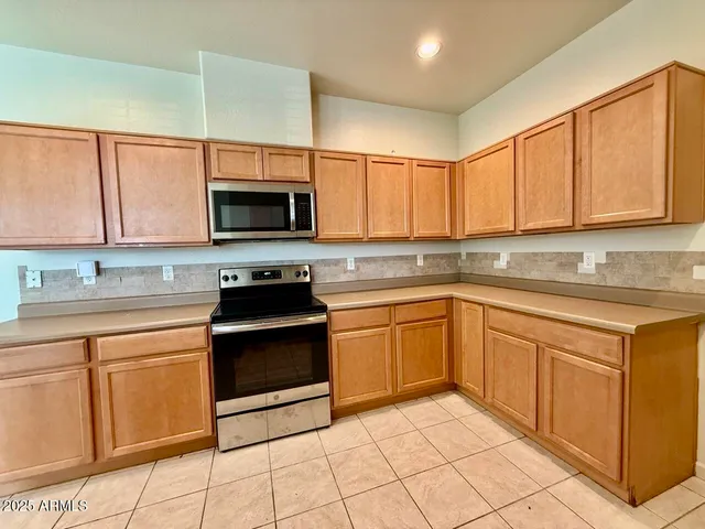 a kitchen with stainless steel appliances granite countertop a stove top oven a sink dishwasher and cabinets with wooden floor