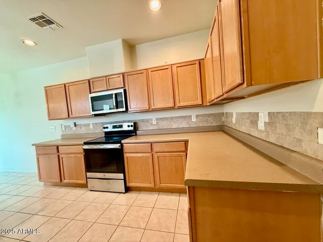 a kitchen with stainless steel appliances granite countertop a stove a sink and a microwave