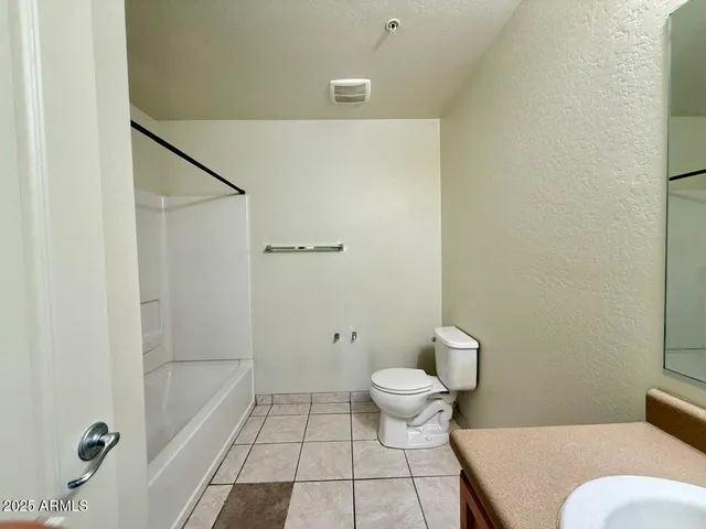 a bathroom with a granite countertop sink a mirror and a bathtub