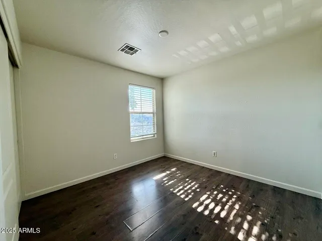 an empty room with wooden floor and closet
