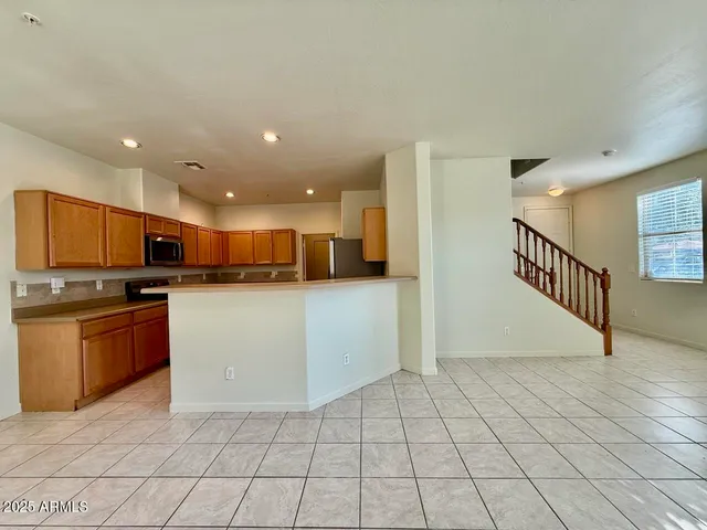 a open kitchen with stainless steel appliances granite countertop a refrigerator and a stove top oven