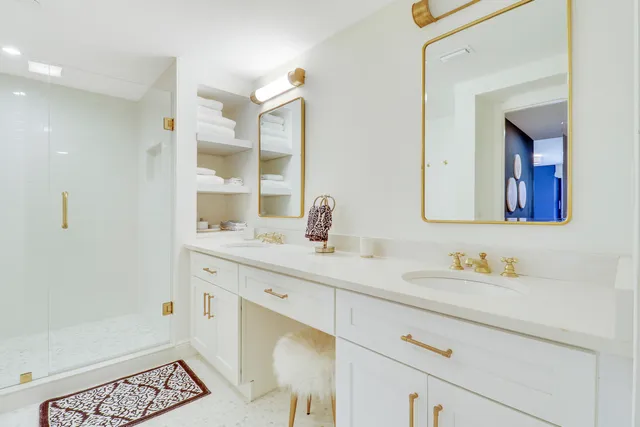 a bedroom with a bed and a large mirror next to a window