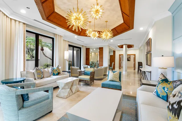 a living room with furniture a chandelier and a dining table