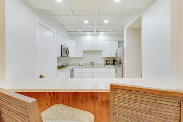 a kitchen with granite countertop white cabinets and white appliances