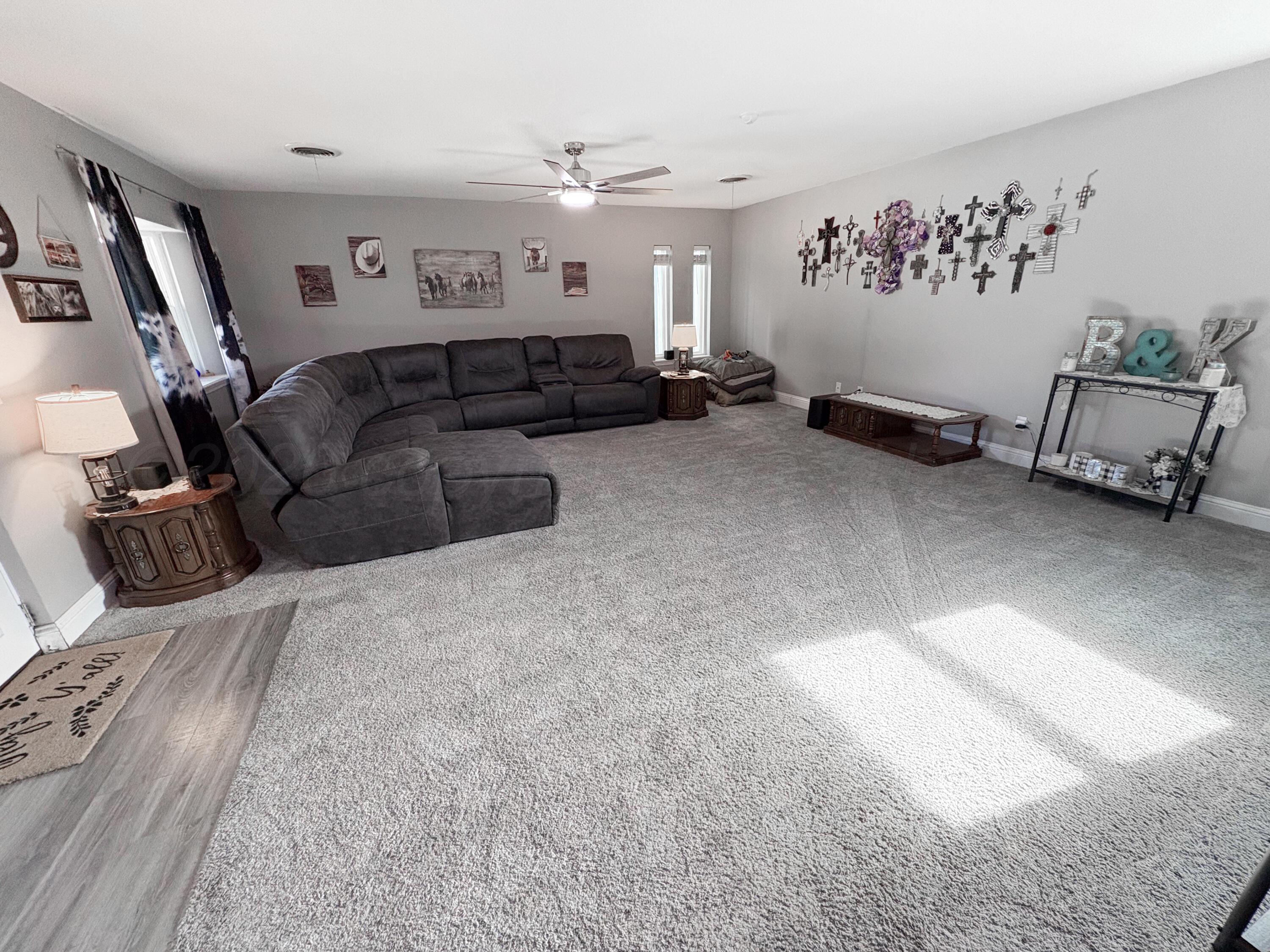 415 Mustang Street Fritch, TX 79036 - Photo 12 of 23 a large bedroom with a bed and a couch