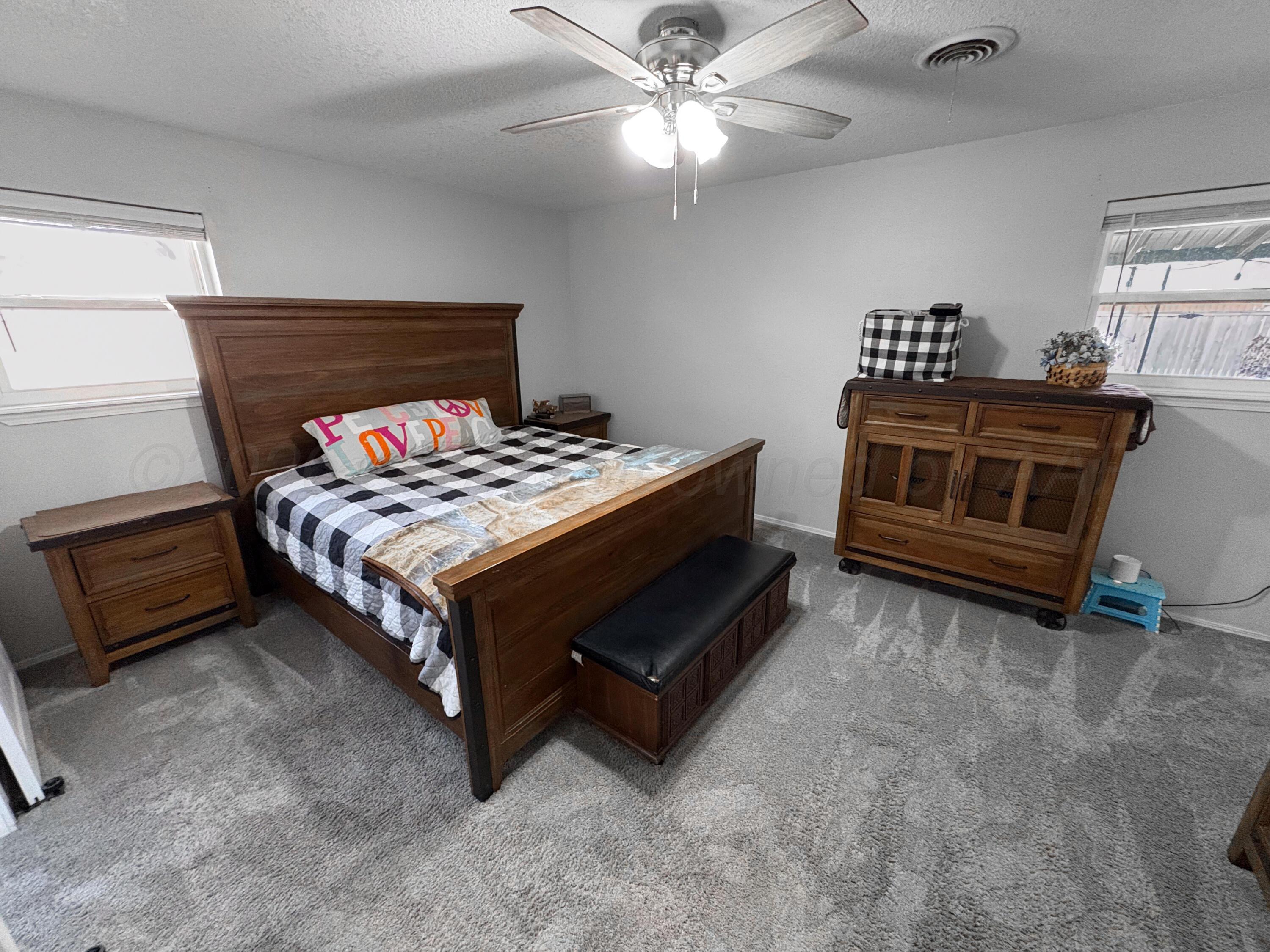 415 Mustang Street Fritch, TX 79036 - Photo 17 of 23 a bedroom with a bed and a ceiling fan