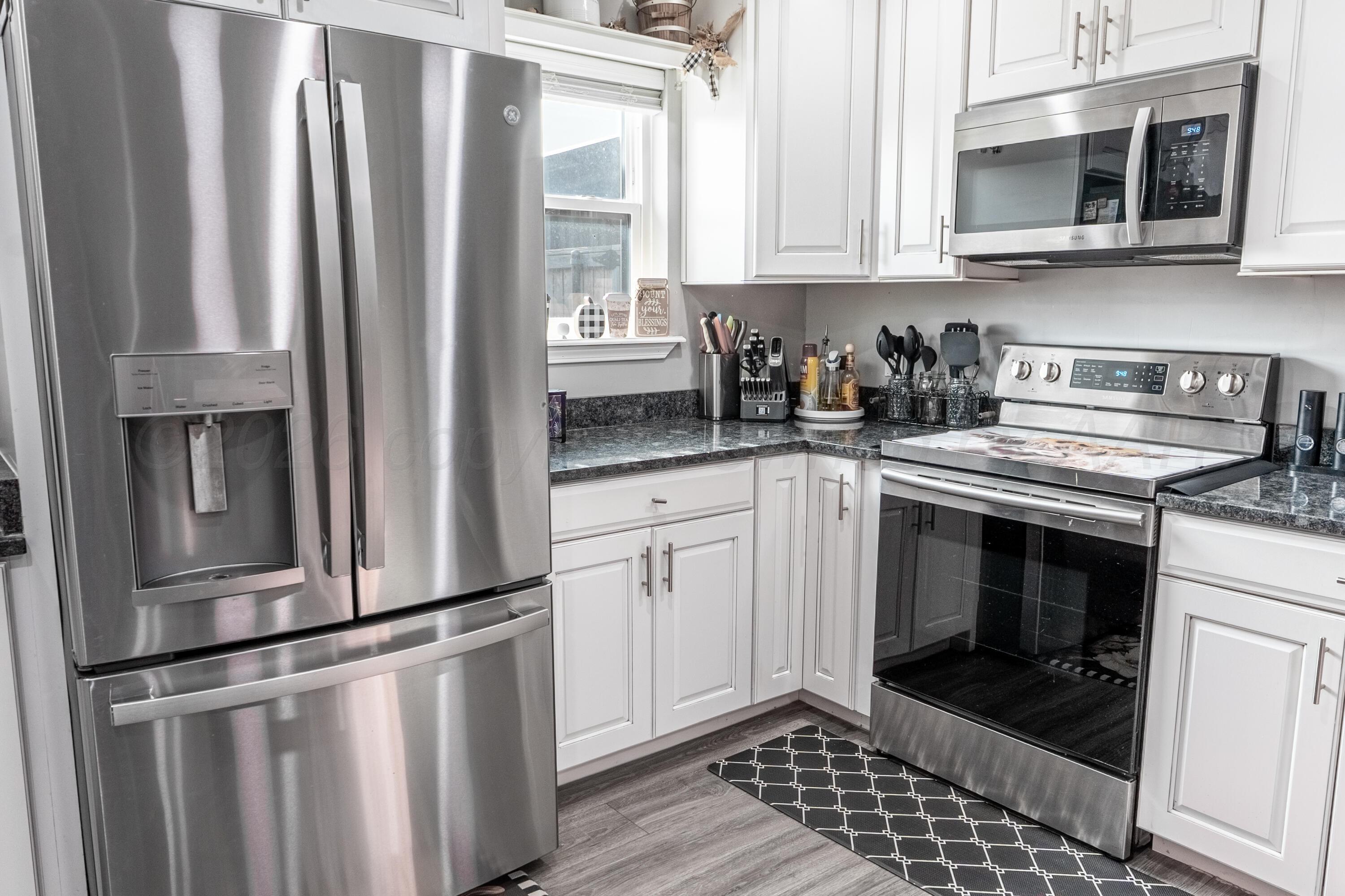 415 Mustang Street Fritch, TX 79036 - Photo 6 of 23 a kitchen with stainless steel appliances granite countertop a stove a microwave and a sink