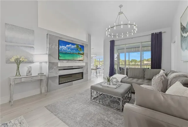 a living room with furniture a chandelier and a flat screen tv