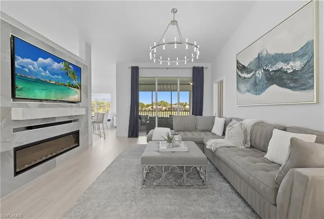 a living room with furniture a dining table and a chandelier