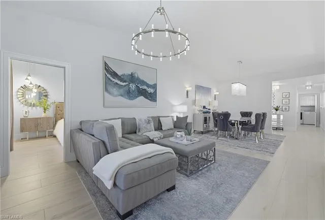 a large white kitchen with a large window a sink and stainless steel appliances