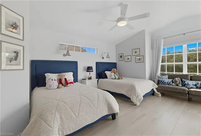 a bed room with two bed and a window